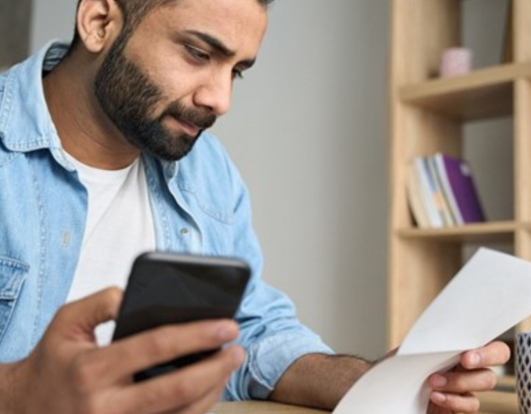stressed man paying invoices, processing paperwork