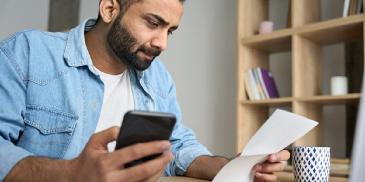 stressed man paying invoices, processing paperwork